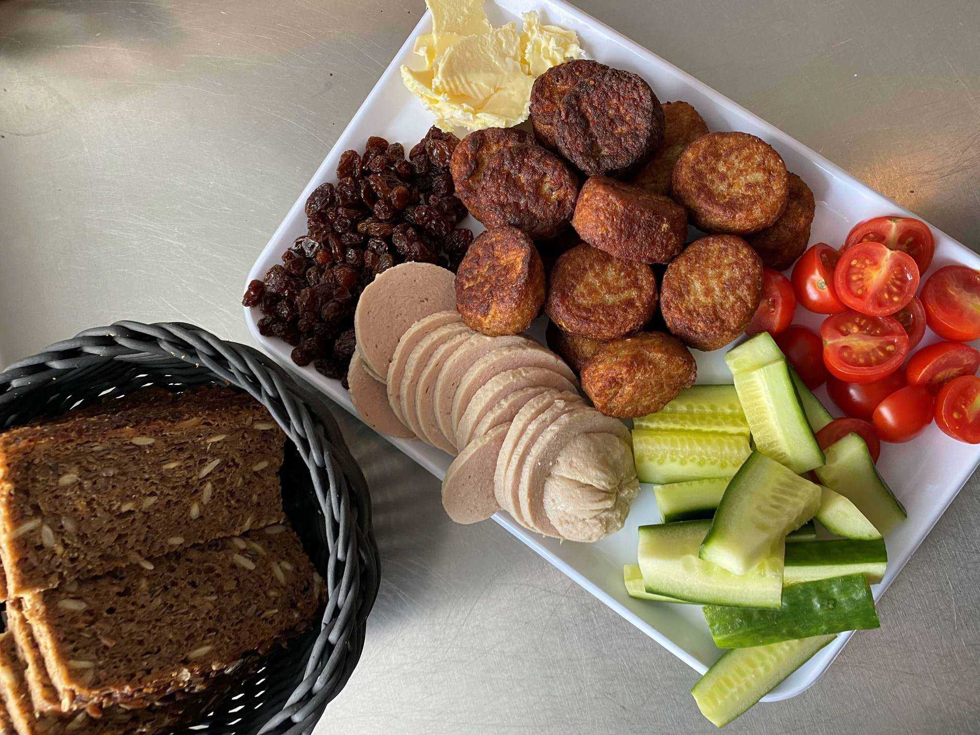 Rugbrødsfad med pølse, fiskefrikadeller, agurk, tomater og rosiner