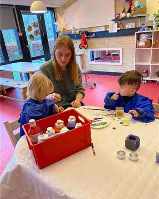 To børn har fundet mange flotte farver frem og er i gang med at lave en gave til deres forældre
